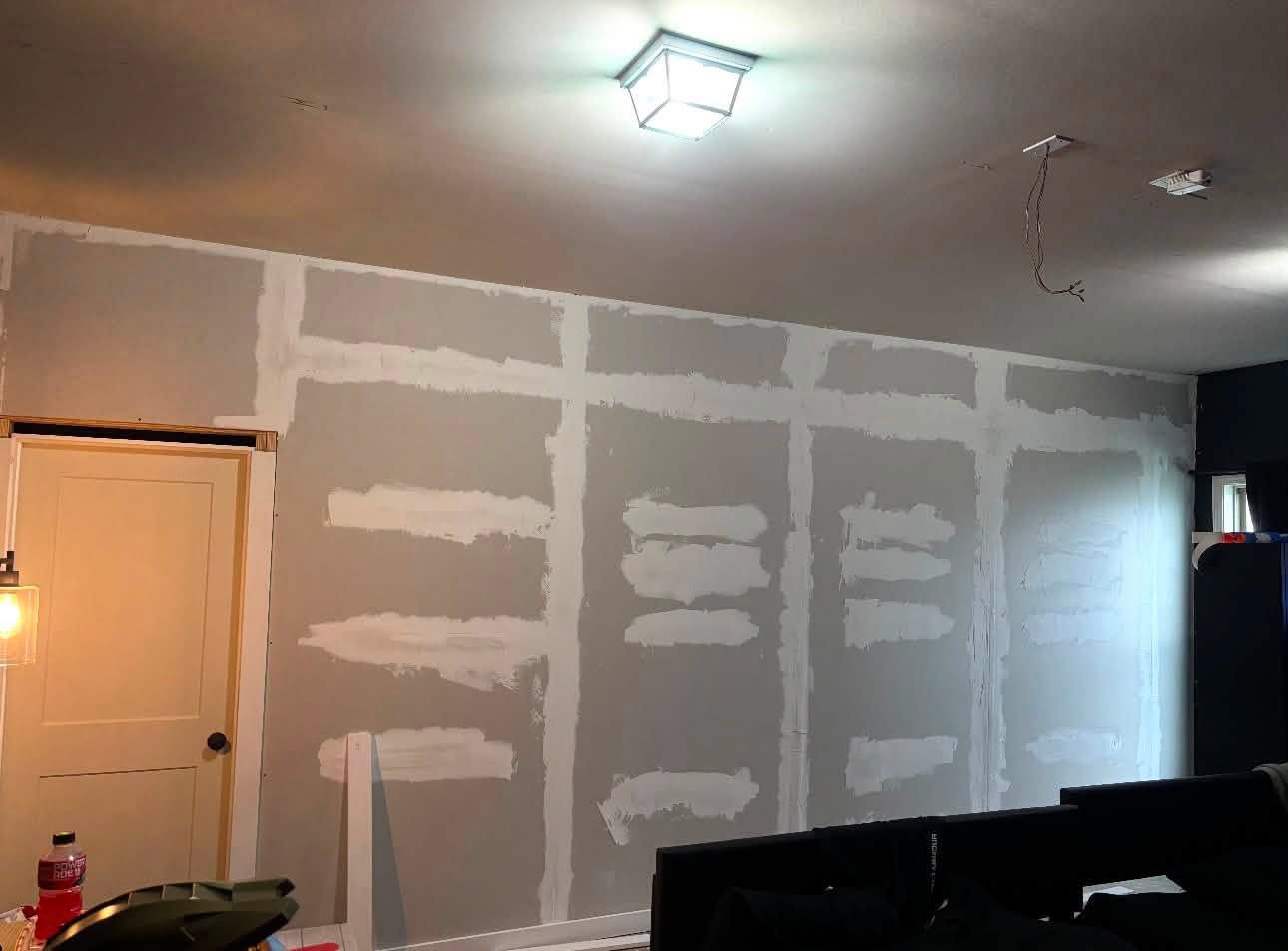 New drywall taped and mudded during a garage-to-bedroom conversion