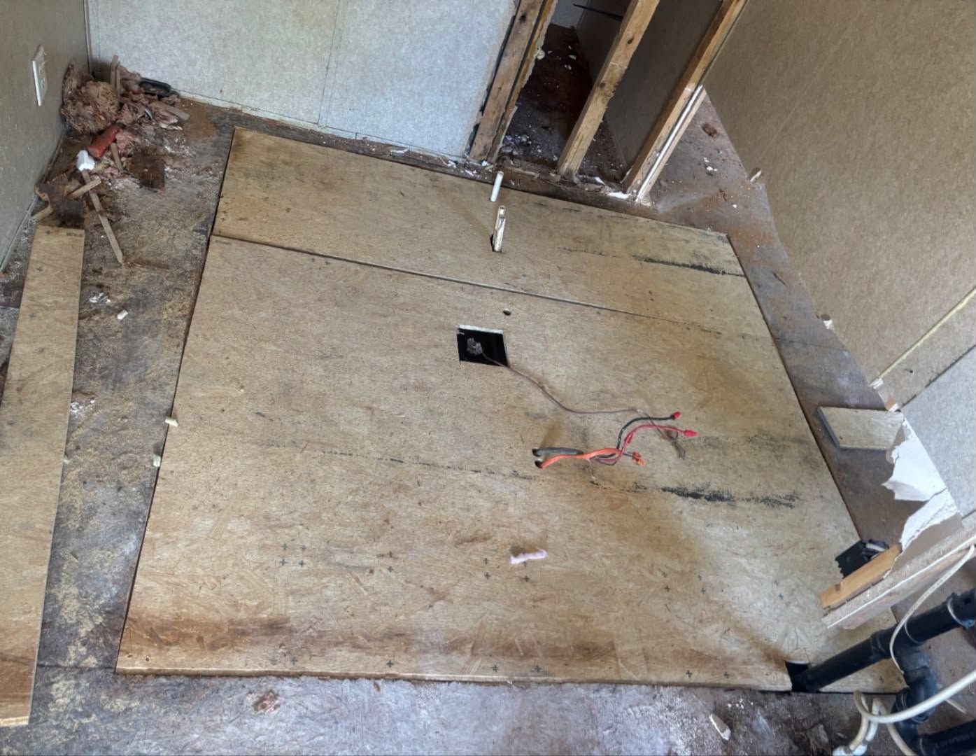 New plywood subfloor section laid in where damaged flooring was removed